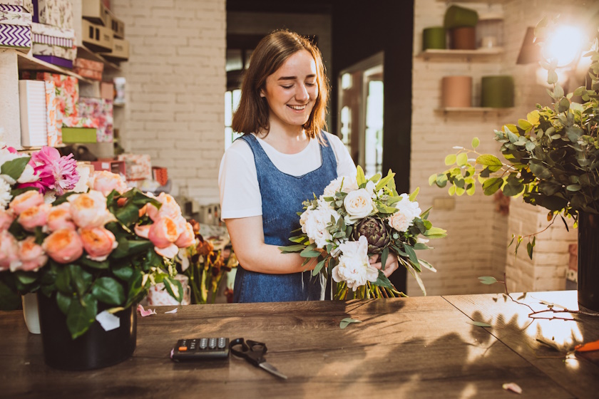 Fleuriste préparant un bouquet de fleurs.